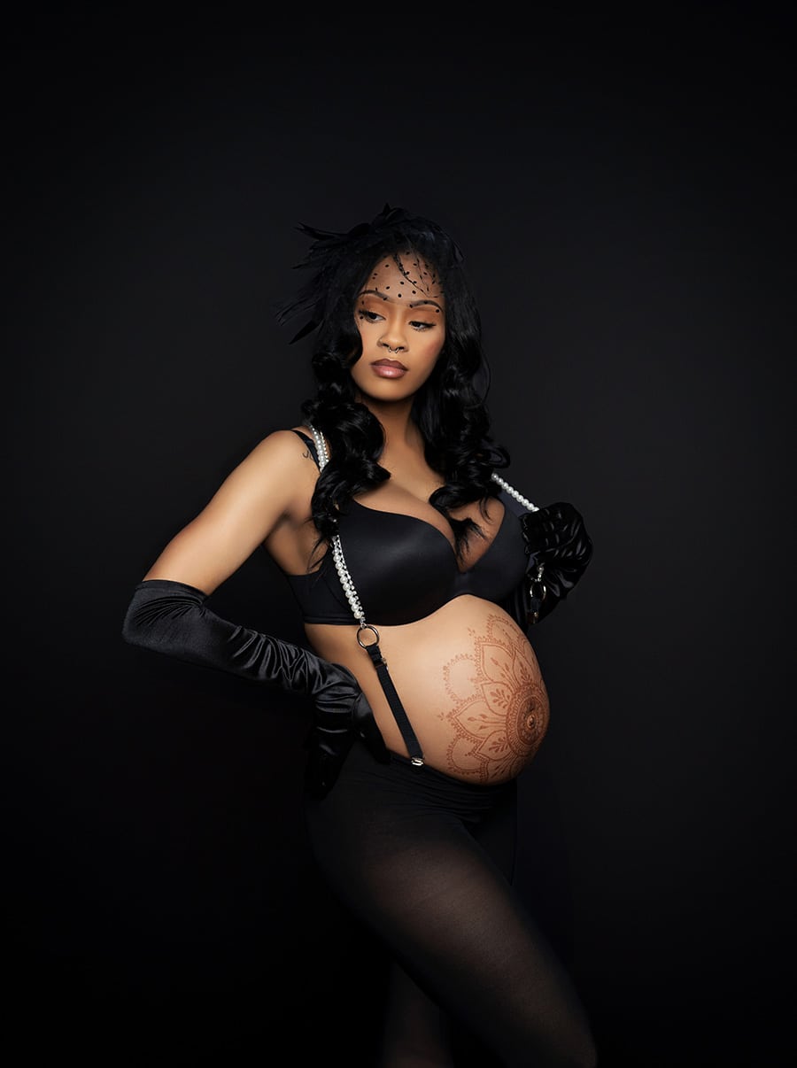 elegant maternity boudoir photo with a modern maternity look dressed in pearls, stockings sexy lingeries